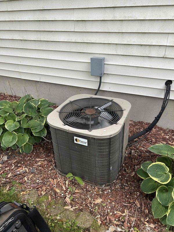 Responded to no cooling complaint on 10+ year old air conditioning system. Upon arrival, system was off. Started unit and observed operation - condenser and compressor engaged properly. Monitored system performance and recorded temperature measurements showing 15-degree temperature split across evaporator coil. Found evaporator coil sweating appropriately along full length, indicating proper refrigerant flow. Discovered severely clogged air filter restricting airflow. Replaced plugged filter with customer-supplied filter. System operating normally at time of departure with proper airflow restored and adequate cooling capacity.