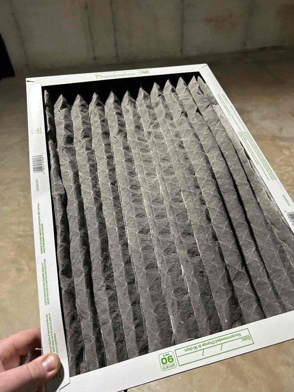 Responded to no cooling complaint on 10+ year old air conditioning system. Upon arrival, system was off. Started unit and observed operation - condenser and compressor engaged properly. Monitored system performance and recorded temperature measurements showing 15-degree temperature split across evaporator coil. Found evaporator coil sweating appropriately along full length, indicating proper refrigerant flow. Discovered severely clogged air filter restricting airflow. Replaced plugged filter with customer-supplied filter. System operating normally at time of departure with proper airflow restored and adequate cooling capacity.