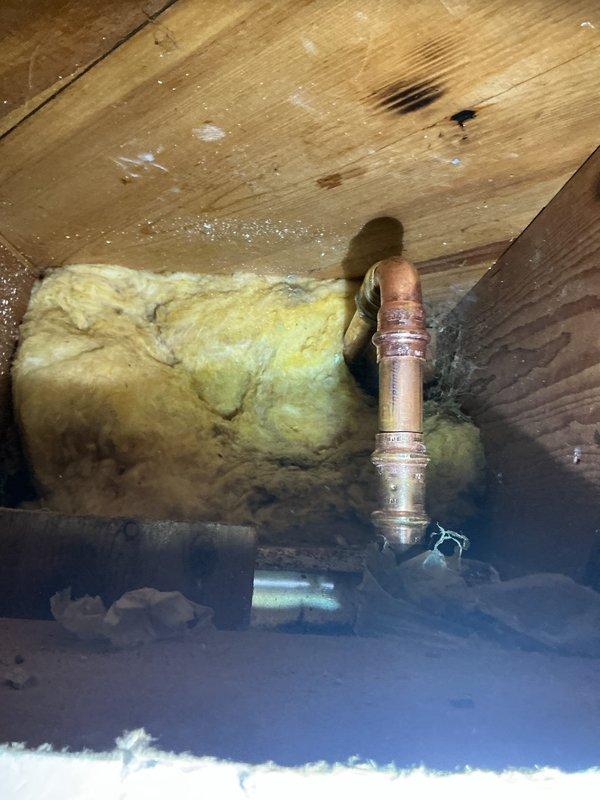Responded to outdoor spigot with trickling water issue. Upon inspection, found the exterior faucet had rolled threads and required complete replacement. Accessed copper supply line from crawl space, removed failed hose bib, and installed new frost-free sillcock with proper sealing at stucco wall penetration. Discussed secondary frozen line concern on opposite side of house for potential future rerouting considerations.
