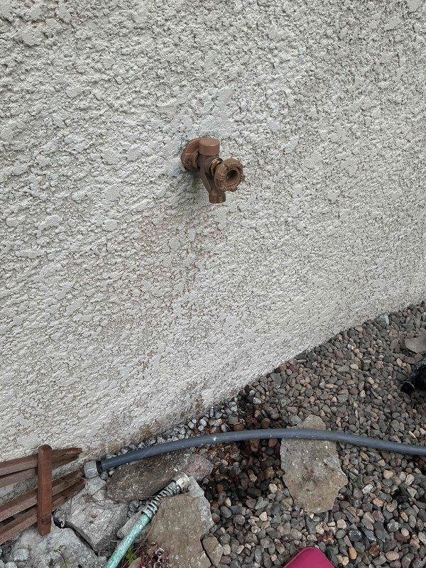 Responded to outdoor spigot with trickling water issue. Upon inspection, found the exterior faucet had rolled threads and required complete replacement. Accessed copper supply line from crawl space, removed failed hose bib, and installed new frost-free sillcock with proper sealing at stucco wall penetration. Discussed secondary frozen line concern on opposite side of house for potential future rerouting considerations.
