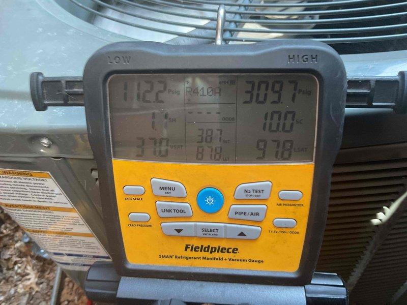Responded to no cooling complaint on 12-year-old Trane system experiencing repeated short cycling issues. Upon arrival, found condenser unit shutting down prematurely with no cooling delivered to home. Connected refrigerant manifold gauges and diagnosed system overcharge condition with pressures reading 112.2 PSIG low side and 309.7 PSIG high side, significantly above manufacturer specifications. This overcharge was causing compressor to cycle on high pressure safety, resulting in inadequate cooling and premature shutdowns observed during previous service visits. Recovered excess refrigerant from system to bring charge levels back to proper specifications per manufacturer guidelines. Monitored system operation through multiple cycles to verify stable pressures and proper compressor runtime. Unit now operating within normal parameters with appropriate cooling delivery throughout home.