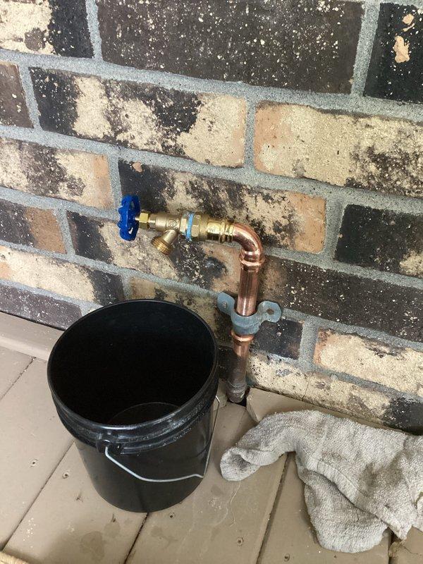 Replaced failed front hose bibb with 3/4" threaded valve and adapter assembly. The original fixture had a compromised solder joint that was causing failure. Removed the defective soldered connection and installed a new brass valve with compression fittings and copper adapters. The new threaded configuration allows for easier future replacement and maintenance without requiring soldering. Secured copper piping to brick wall with mounting brackets to ensure proper support. Tested valve operation and verified proper water flow and shutoff control upon completion.