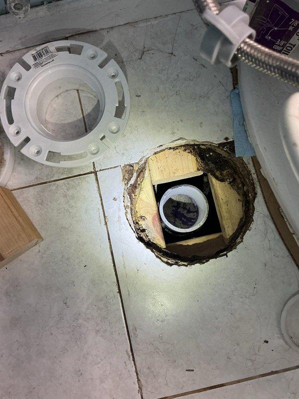Returned to complete toilet installation after subfloor repair work. The existing floor surrounding the closet flange showed significant deterioration and structural damage, requiring complete reconstruction of the subfloor section beneath the flange location. Removed compromised flooring material and reinforced underlying support structures to ensure proper weight distribution and stability. Installed new closet flange with secure mounting to the rebuilt subfloor. Reset toilet onto the new flange assembly with proper wax ring seal and mounting hardware. Verified proper drainage function and secure installation upon completion.