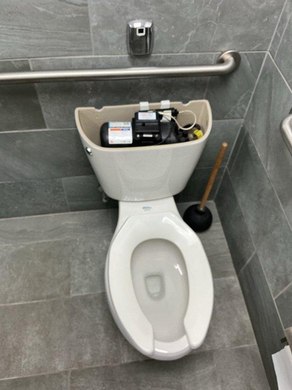 Responded to service call for malfunctioning automatic flush toilets and severely clogged urinal. Diagnosed urinal blockage located past the trap requiring fixture removal. Removed wall-mounted urinal from mounting bracket and cabled drain line approximately 20 feet to clear obstruction. Confirmed drainage by running water through line with hose to verify no backup. Reinstalled urinal, tested flush valve operation, and verified proper drainage with no leaks. Provided quote for replacement of six automatic flush toilets with standard mechanical flush valves to eliminate ongoing battery maintenance issues.