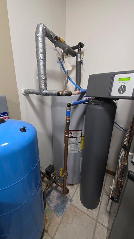 Responded to service call for non-functional electric water heater that had reached end of service life at 25 years old. Removed and properly disposed of existing 50-gallon electric water heater. Installed new 50-gallon electric water heater with proper electrical connections, copper supply lines, and pressure relief valve. Configured hot and cold water piping with appropriate shut-off valves and insulated all exposed pipes to prevent heat loss and condensation. Integrated new unit with existing water treatment system and pressure tank. Tested all connections for leaks, verified proper electrical operation, and confirmed adequate hot water delivery throughout the system.