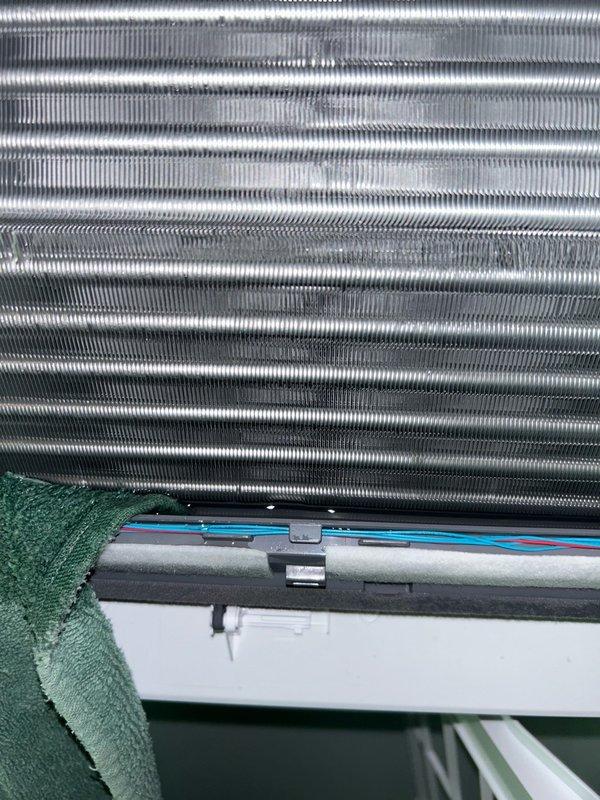 Responded to warranty service call for two mini split indoor units leaking condensate onto flooring. Found both drain lines completely obstructed with black sludge and debris buildup. Manually drained water from smaller head unit and cleared blockage from larger head by blowing CO2 through drain line from basement access point, removing significant accumulation of organic matter. Verified proper drainage restored to both units with no further leakage from drain pans. Recommended preventative maintenance tune-up to avoid recurrence of drain line blockages.