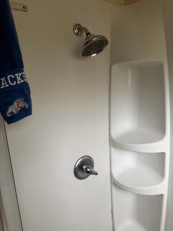 Responded to water leak originating from upstairs shower affecting downstairs area. Upon inspection, identified broken shower arm as primary source of leak. Accessed plumbing through wall cavity, removed damaged section of pipe and faulty drop ell assembly. Installed replacement pipe section with new drop ell fitting, ensuring proper alignment and secure connections. Completed repair by installing new chrome shower arm and verified system integrity with no further leakage detected.
