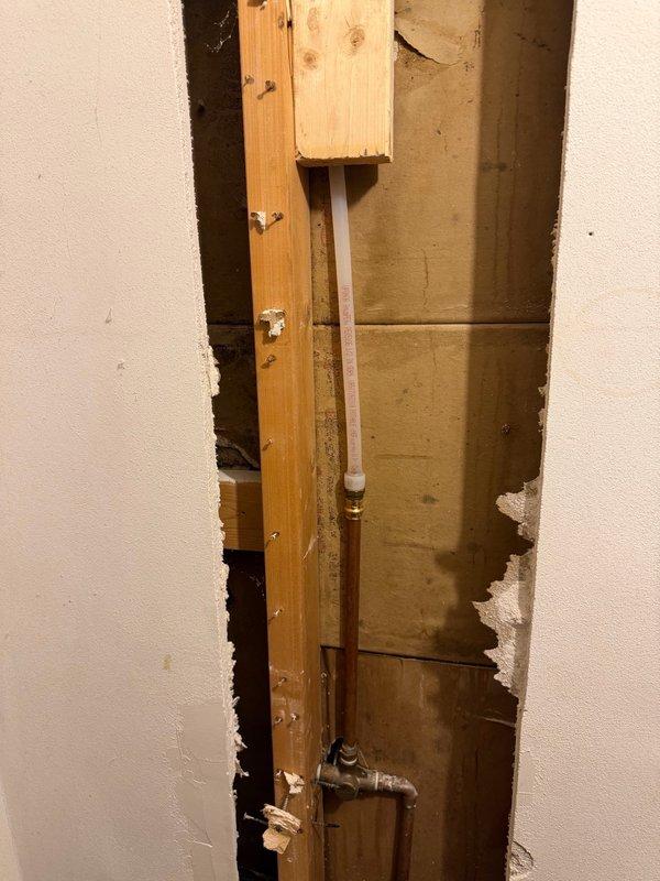 Responded to water leak originating from upstairs shower affecting downstairs area. Upon inspection, identified broken shower arm as primary source of leak. Accessed plumbing through wall cavity, removed damaged section of pipe and faulty drop ell assembly. Installed replacement pipe section with new drop ell fitting, ensuring proper alignment and secure connections. Completed repair by installing new chrome shower arm and verified system integrity with no further leakage detected.
