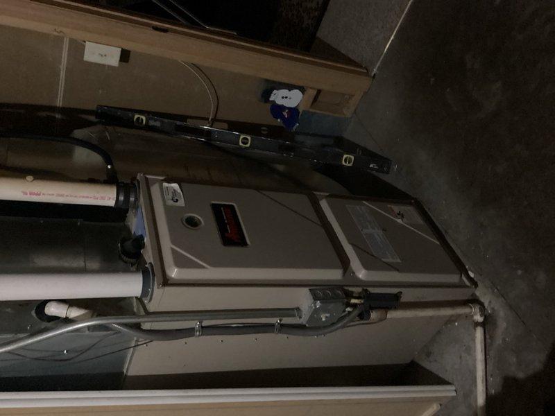 Responded to no cooling complaint on 20-year-old R22 system with reported buzzing at outdoor unit and non-operational fan. Upon arrival, cycled system and confirmed outdoor unit operational. Identified severely restricted air filter causing reduced airflow and only 10-degree temperature split across evaporator coil even after filter replacement. Inspected outdoor condenser unit and found heavy dirt accumulation on coil, though all electrical components tested within manufacturer specifications. Detected low refrigerant charge on R22 system. Found evaporator coil significantly plugged with debris and active refrigerant leak at coil location causing moisture damage on top of furnace cabinet. Documented equipment condition with photographs showing outdoor condenser placement and indoor furnace/evaporator assembly. Reviewed system age, overall condition, and repair needs with homeowner, discussing both immediate concerns and anticipated future failures given equipment age and R22 phase-out