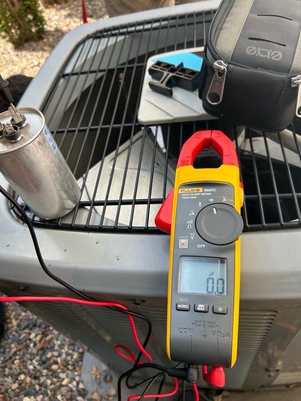Responded to no cooling complaint following recent power surge and outage. Upon arrival, both AC systems were operational after breaker reset, but full diagnostic inspection was requested. Tested dual run capacitor on first unit (right side) and found complete failure, reading 0/4.3 MFD versus rated 40/5 MFD. Compressor was only able to start with assistance from existing hard start kit due to failed capacitor. Replaced failed dual run capacitor and verified normal system operation restored. Inspected second AC unit and found all major components functioning properly. Removed rodent nest from second unit. Verified refrigerant operation on both systems operating within normal parameters. Measured and confirmed supply and return air temperatures on both units within acceptable range. Noted humidifier solenoid stuck in open position requiring future service if correction desired. Both AC systems left operating normally with proper cooling restored.