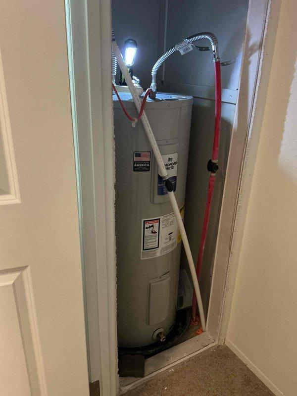 Responded to no hot water complaint on 6-year-old electric water heater. Upon inspection, discovered tank rupture requiring immediate replacement. Removed and properly disposed of failed unit. Installed new Bradford White 30-gallon electric water heater with 10-year warranty in utility closet location. Connected all water supply lines, installed temperature and pressure relief valve, and verified proper electrical connections. Tested unit operation and confirmed hot water delivery to fixtures throughout residence.