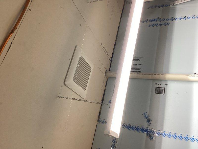 Installed new bathroom exhaust fan in mechanical room ceiling above work station with standard on/off switch control. Mounted fan unit in existing sheetrocked ceiling and routed rigid ductwork through attic space to exterior termination point with weatherproof hood. Ensured proper clearance from existing furnace venting system, maintaining minimum 12-inch separation per code requirements. Completed electrical rough-in and connected fan to building power supply. Installed hose bib connection in garage for power washer use. All installations tested and verified operational upon completion.