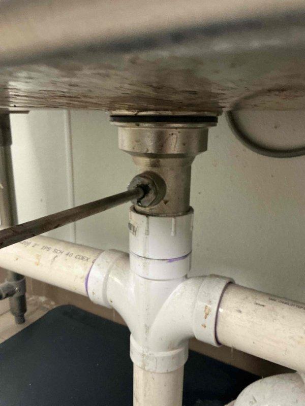 Assessed triple-basin commercial sanitizer sink with deteriorating drain basket strainers and gasket rings. Initial replacement parts were incompatible with existing fixtures. Documented existing plumbing configuration including PVC drainage system and sink drain assemblies. Provided bid for complete replacement of all three sink basket strainers with proper specifications.