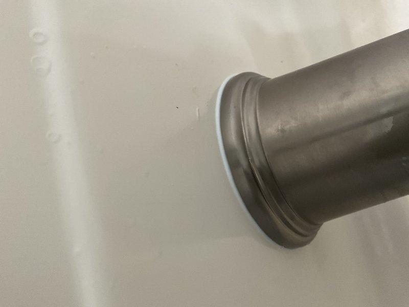 Responded to water leak originating from bathtub/shower area with visible water damage on ceiling below. Upon inspection, identified failed silicone seal around tub spout as source of leak. Removed deteriorated caulking and resealed tub spout with fresh plumber's silicone to restore watertight seal and prevent further water intrusion.