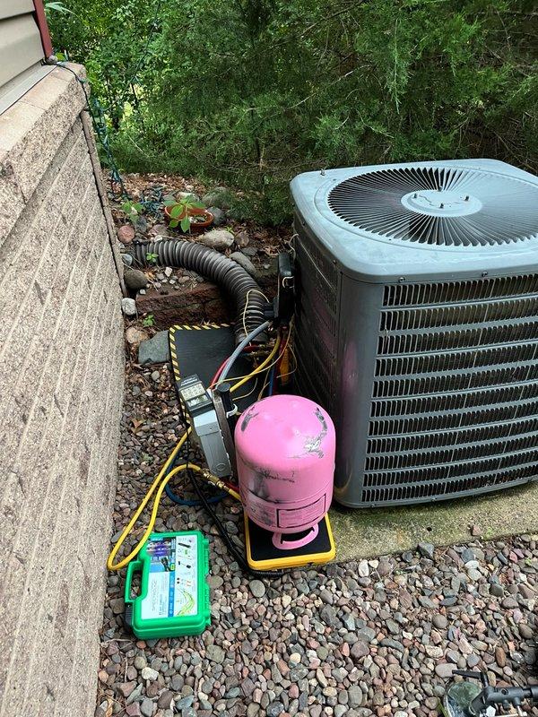 Responded to no cooling complaint with water leaking from ceiling into living space. Upon arrival, located attic-mounted air handler and found evaporator coil with residual ice formation, indicating previous freeze-up condition. Most ice had already melted, causing the interior water leak. System had been shut down prior to arrival.

Inspected evaporator coil and confirmed clean condition with adequate airflow, though noted system was operating without air filter installed. Performed refrigerant charge analysis on R-410A system and determined unit was significantly low on refrigerant, which was the root cause of coil freeze-up and subsequent water damage.

Recharged system to manufacturer specifications and added UV dye to aid in future leak detection. Verified proper operation by measuring operating pressures, achieving subcooling readings of 11-14 degrees and supply air temperature drop of 20-23 degrees across the coil. Allowed system to run for 15-minute test cycle to confirm stable