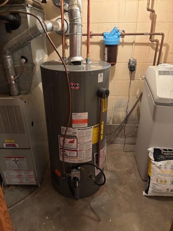 Responded to callback for water heater backdrafting issue. Upon arrival, found that the combustion air intake from outside had been previously covered, restricting proper ventilation. The homeowner had already removed the siding that was blocking the fresh air intake and installed chicken wire screening over the opening. Inspected the fresh air intake piping from the basement through to the exterior termination point. Verified that the obstruction had been cleared and confirmed natural draft operation of the Ruud water heater was restored. Recommended upgrading to finer mesh screening to prevent small animals and debris from entering the combustion air intake system. Documented proper draft operation with video confirmation showing normal venting performance after the intake was uncovered.