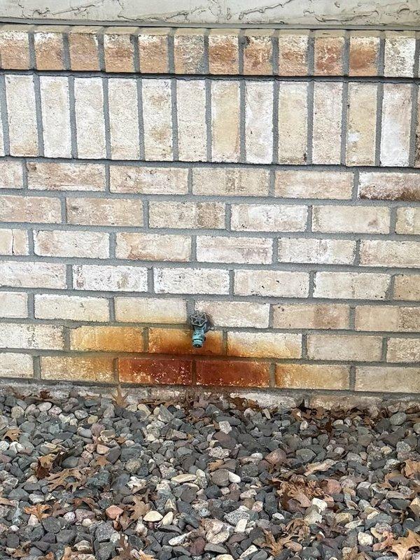 Responded to exterior faucet leakage issues affecting two hose bibs. Upon inspection, identified active leaking from backflow preventer assembly on primary spigot, causing rust staining on brick facade and moisture infiltration at foundation level. Removed malfunctioning hose attachment and backflow device from leaking unit. Evaluated second exterior faucet for similar wear and potential failure points. Addressed immediate water intrusion concerns to prevent further structural damage to masonry and interior basement walls.