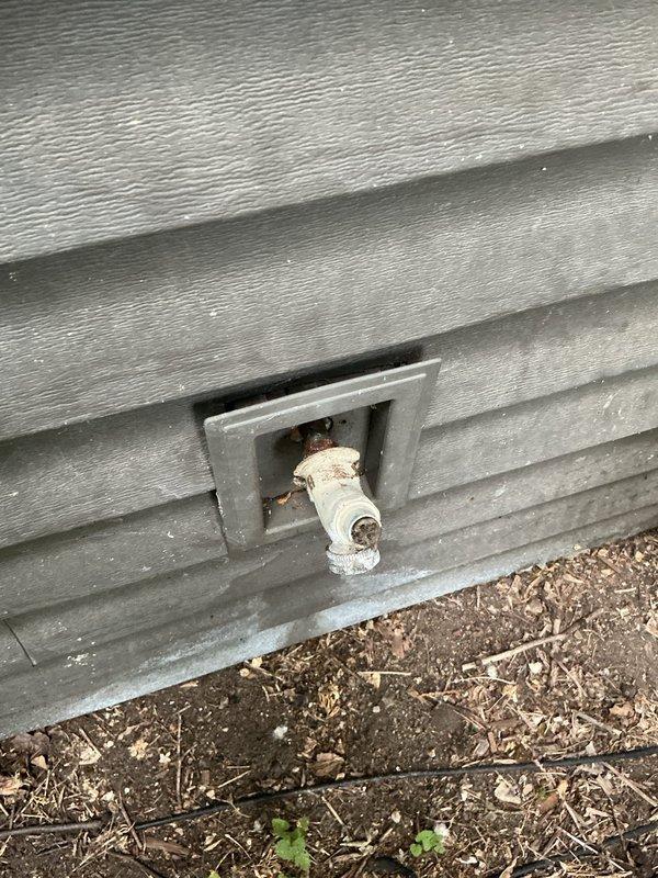 Responded to a non-functioning outdoor hose spigot that would not shut off. Upon inspection, determined that internal seals were worn out and the spigot had corroded to the point where it could not be removed using conventional methods. Due to severe corrosion preventing the spigot from being unscrewed from the exterior, accessed the connection point by cutting an access hole in the interior wall behind the fixture. Removed the deteriorated spigot assembly from the interior access point. Installed a new hose spigot, properly securing it to the exterior siding with appropriate mounting hardware. Tested the new spigot for proper operation, confirming smooth on/off functionality and verified no leaks were present at the connection points or valve body.
