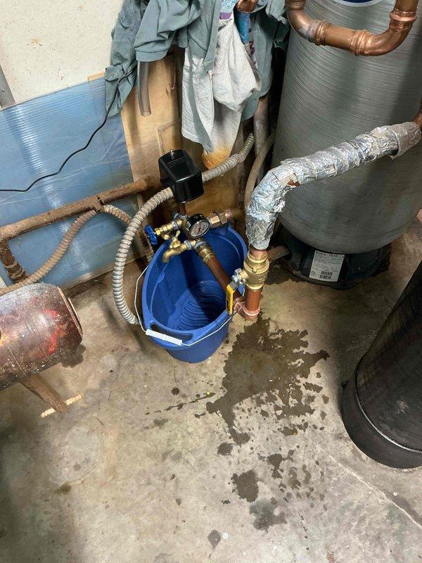 Responded to water leak in basement with source initially unknown. Upon inspection, identified active leak at pressure tank tee assembly. Removed failed tee fitting and installed new pressure tank tee assembly to restore proper function and eliminate water intrusion. System tested and verified leak-free upon completion.