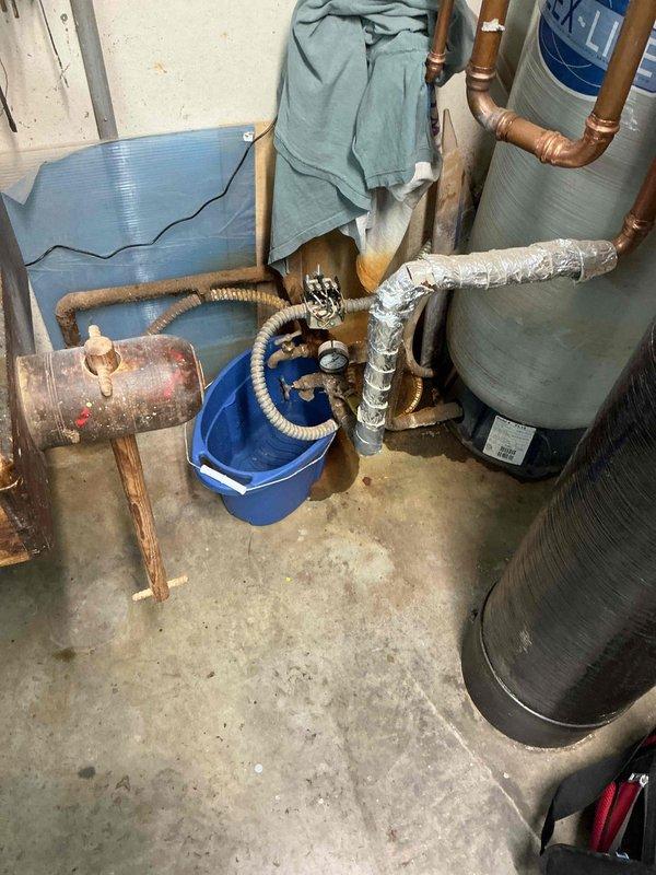 Responded to water leak in basement with source initially unknown. Upon inspection, identified active leak at pressure tank tee assembly. Removed failed tee fitting and installed new pressure tank tee assembly to restore proper function and eliminate water intrusion. System tested and verified leak-free upon completion.