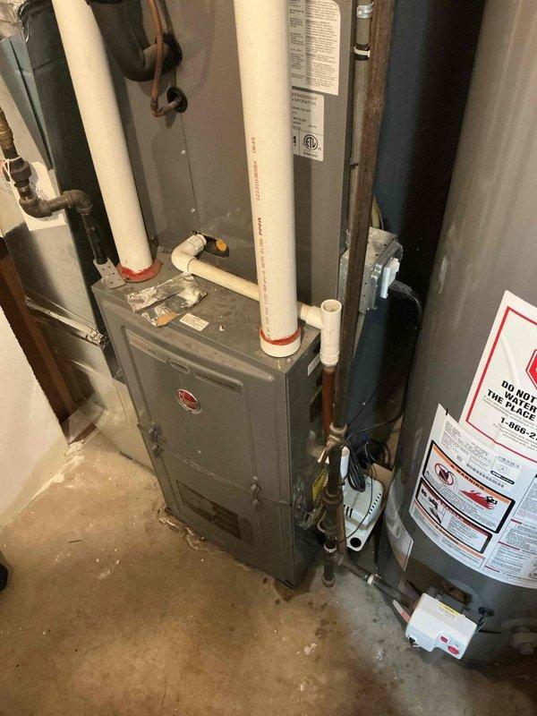 # HVAC Service Completed

Responded to a no cooling call on a 10+ year old system where water leakage was initially reported near the furnace. Upon arrival, confirmed active water leak originating from a failed condensate pump in the mechanical area. System had been shut down with furnace fan left in "on" position to prevent further water damage.

Diagnosed the condensate pump as the source of the leak, which had been allowing water to overflow from the drain pan onto the surrounding floor. The failed pump was unable to evacuate condensate water produced during normal air conditioning operation, causing water accumulation and spillage in the utility area.

Removed the defective condensate pump and installed a new replacement unit. Reconnected all condensate drain lines and electrical connections to the new pump. Verified proper pump operation and confirmed adequate drainage of condensate water from the system. Tested the air conditioning system through a complete cooling cycle to ensur