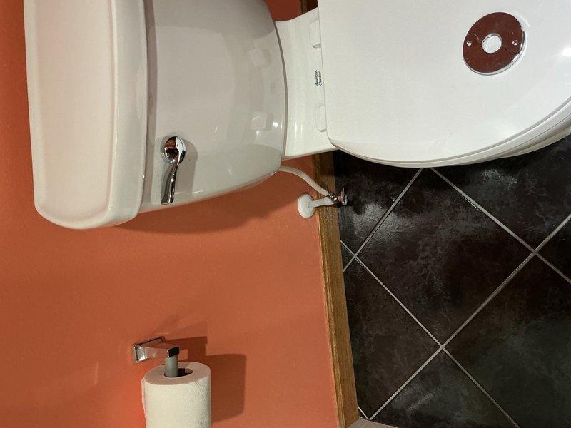 Responded to active water leak behind toilet with water supply shut off to home. Upon inspection, identified pinhole leak in copper elbow fitting within wall cavity behind toilet fixture. Removed compromised copper elbow and accessed plumbing below toilet level. Installed new PEX supply lines running from lower access point up through wall to toilet location. Installed new shut-off valve and reconnected to toilet supply line. Tested system for proper operation and verified no additional leaks present. Restored water service to home.