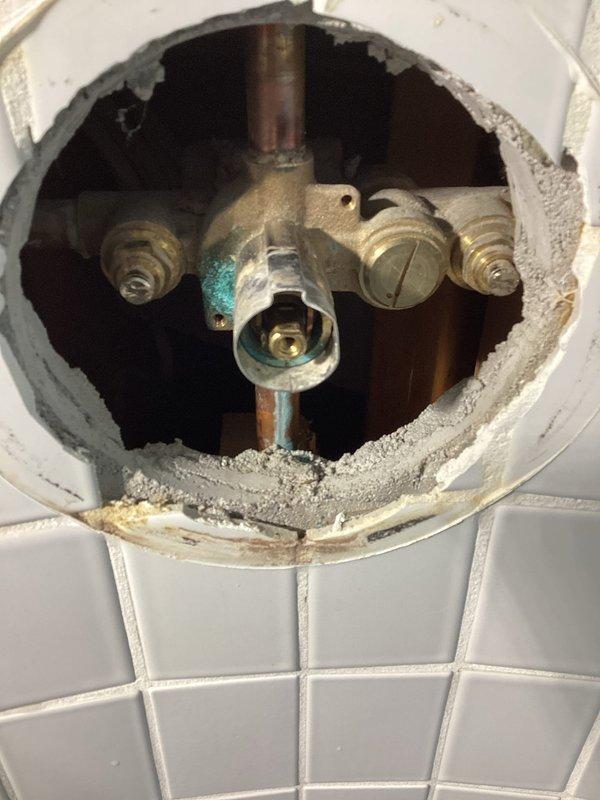 Installed four vacuum breakers on exterior hose bibs to prevent backflow contamination of the potable water supply. Investigated no hot water issue at master bathroom shower by cutting access opening through closet wall to expose shower valve assembly. Upon inspection, found corroded valve components with significant oxidation preventing proper hot water flow. Due to limited access and valve condition, recommended complete shower valve replacement, as repair attempt through existing access point was not feasible.