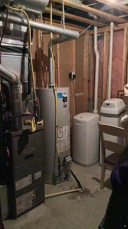 Responded to no hot water condition caused by failed gas valve on existing water heater. Removed and properly disposed of original unit. Installed new 50-gallon natural gas standard vent water heater in basement mechanical room in place of like unit. Connected yellow flexible gas line, white PVC venting, and all water supply lines per code. Verified proper clearances from furnace and other mechanical equipment. Tested all connections for leaks, confirmed proper venting operation, and verified hot water delivery throughout residence. Permit obtained and installation completed to current plumbing code requirements.