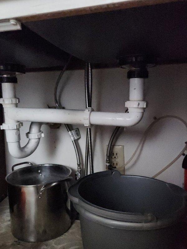Responded to clogged kitchen sink with drainage issues. Upon inspection, found dual-basin sink with standing water and confirmed blockage in drain line. Successfully cleared obstruction using cable snake equipment through the drain assembly. Verified proper drainage flow restored to both basins and confirmed P-trap connections under sink were secure with no active leaks detected at time of service completion.