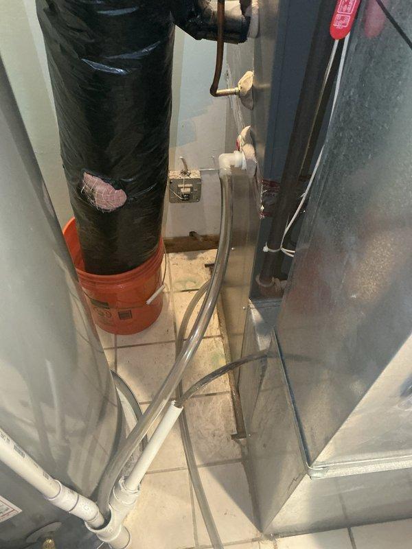 Responded to report of water leaking from indoor unit in furnace area. Upon inspection, found condensate drain line from evaporator coil completely plugged, causing drain pan to overflow into the mechanical room. Cleared blockage from condensate drain system and verified proper drainage flow. Confirmed AC system cooling operation normal and all components functioning properly after drain restoration.