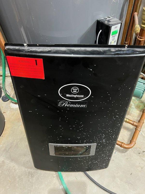 Responded to no hot water call on Westinghouse Premium boiler less than 10 years old. Found unit completely inoperative with tripped breaker caused by slow leak from top-mounted air bleeder valve that dripped water into internal components, shorting out electrical system. Drained system completely and replaced failed air bleeder valve assembly. Replaced damaged circuit board and control components that sustained water damage from leak. Refilled system, purged air from lines, and restored unit to full operation with hot water service confirmed.