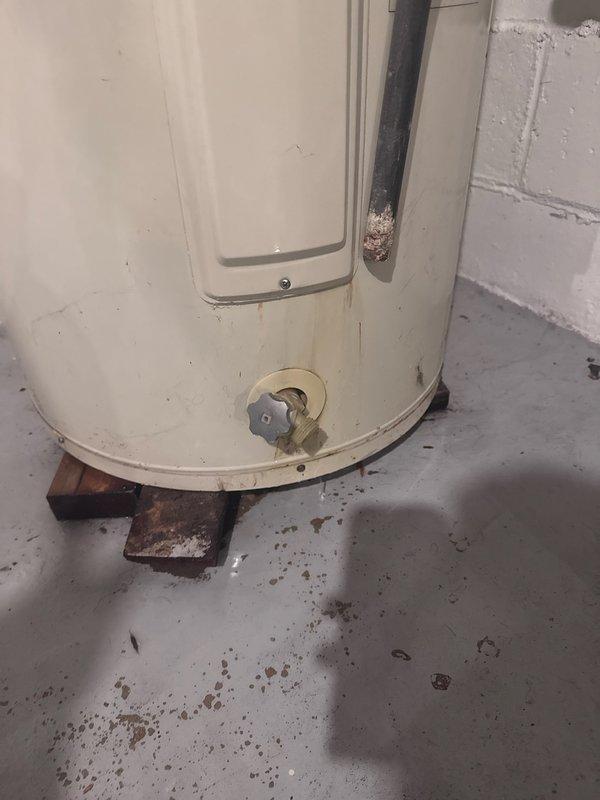 Responded to continuous water leak originating from water heater in lower electrical panel area. Upon inspection, identified active leak from bottom element panel indicating compromised tank integrity. Water heater showed significant age-related deterioration with visible rust staining, corrosion at base, and moisture damage on surrounding concrete floor. Tank failure determined to be non-repairable due to structural compromise. Recommended and scheduled complete water heater replacement to resolve leak and restore hot water system functionality.