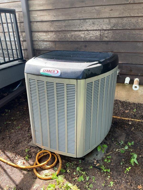 Completed comprehensive air conditioning maintenance tune-up on Lennox outdoor condenser unit. Performed full system inspection including air filter evaluation, evaporator drain verification, coil cleaning, and electrical component check. Removed access panels, rinsed condenser coils, extracted debris and leaves from unit bottom, and verified all wiring connections were secure with no evidence of rodent intrusion. System startup confirmed proper operation with 20-degree temperature differential across the evaporator coil, indicating optimal cooling performance.