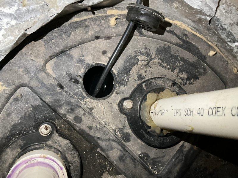 Responded to mechanical room floor drain backup occurring during laundry use. Verified customer concern and traced drainage system configuration. Identified that both floor drain and laundry drain discharge into a sewage ejection pump/lift station assembly. Inspected ejection pump tank and found it filled to capacity with wastewater. Diagnosed pump failure as root cause of drainage backup. Documented pump malfunction with photographic evidence showing corroded drain assembly, accumulated sediment, and pump components including actuator stem and discharge piping. Referred job to licensed plumbing contractor for pump repair or replacement as no corrective work was performed during diagnostic visit.