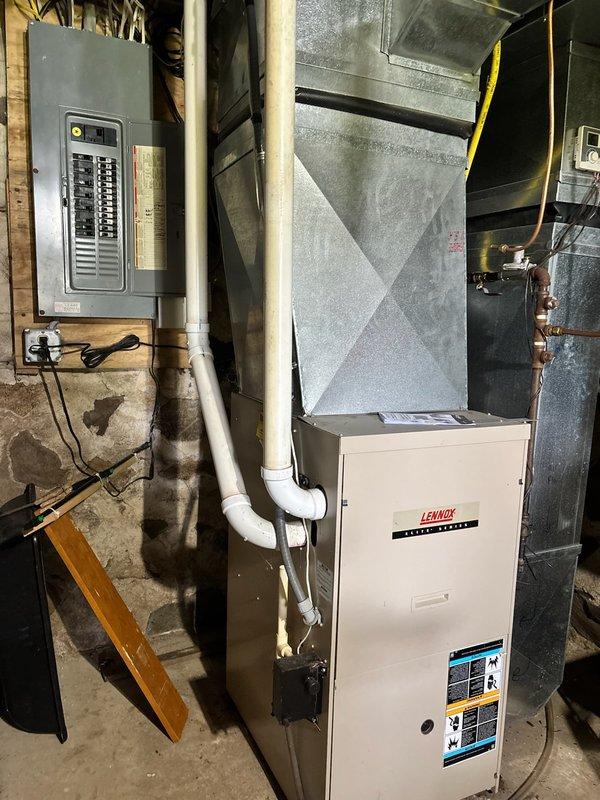 Completed furnace maintenance tune-up on 22-year-old Lennox heating system. During inspection, discovered inducer motor producing excessive noise at startup and drawing amperage beyond manufacturer specifications. Documented equipment condition with photos showing basement mechanical room installation, including furnace unit, ductwork, electrical panel, and associated piping systems. Recommended comfort advisor consultation and draft motor replacement due to failing inducer motor operation. System currently operational but requires component replacement to prevent failure during heating season.