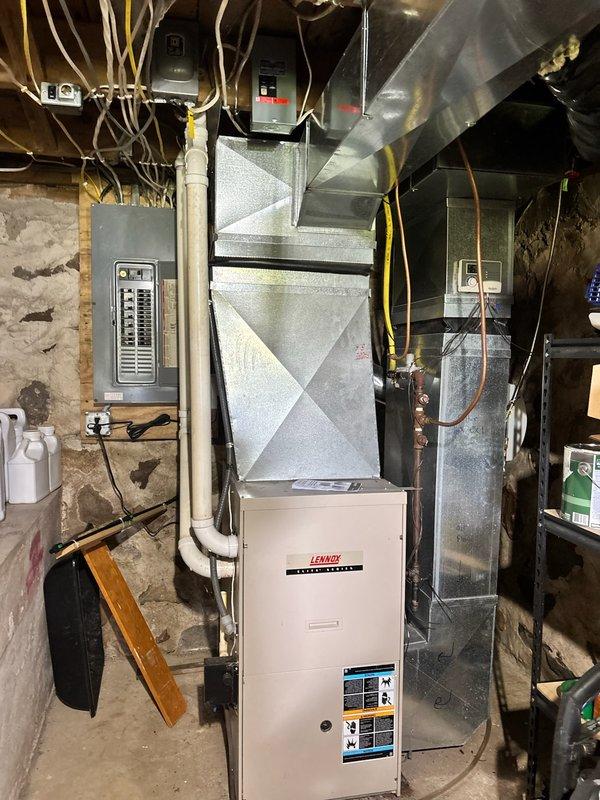 Completed furnace maintenance tune-up on 22-year-old Lennox heating system. During inspection, discovered inducer motor producing excessive noise at startup and drawing amperage beyond manufacturer specifications. Documented equipment condition with photos showing basement mechanical room installation, including furnace unit, ductwork, electrical panel, and associated piping systems. Recommended comfort advisor consultation and draft motor replacement due to failing inducer motor operation. System currently operational but requires component replacement to prevent failure during heating season.