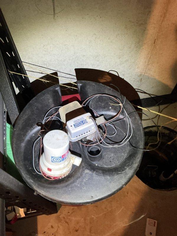 Responded to a sump pump system requiring code compliance for a home sale. The primary sump pump was operational, but the battery backup pump had never been properly connected and was improperly positioned in the basin. Disassembled both the primary pump and battery backup system, installed a new check valve to ensure proper flow direction and prevent backflow, and reassembled both pumps with correct positioning and electrical connections. The battery backup system is now fully functional and integrated with the primary pump, bringing the entire sump pump assembly up to code requirements.