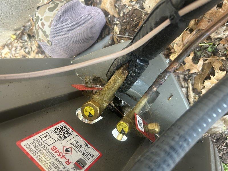 Responded to warranty call for recently installed condenser unit. Upon inspection, discovered compressor was not secured to mounting pad and refrigerant lines were bent, preventing proper installation of mounting bolts. Additionally found service valve caps missing from both ports. Documented conditions with photographs showing unsecured compressor, bent copper lines, debris accumulation in unit base, and exposed service valves. Unit currently operational but requires follow-up visit to properly secure compressor, straighten or replace refrigerant lines as needed, and install proper service valve caps. Submitted work order for corrective action and scheduled callback with customer.