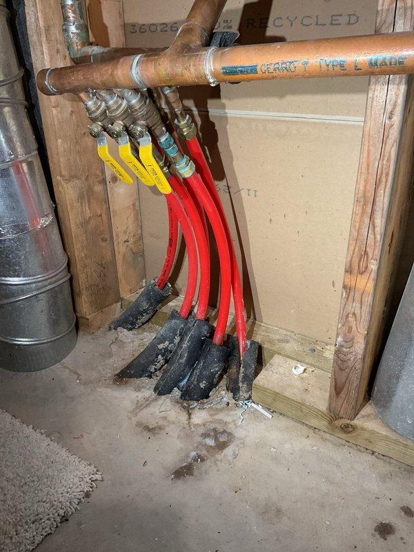 Conducted comprehensive assessment of whole-home in-floor radiant heating system experiencing multiple leaks at manifold connections and zone valves. Identified necessary repairs including replacement of T-fitting in bedroom ceiling and basement, three-port manifold replacement near air handler, and one Erie zone valve. Recommended upgrading expansion tank to 30-gallon capacity with wall relocation and proper strapping, installation of new pressure relief valve and automatic air vent, and complete boiler maintenance service with cleaning. Documented existing conditions with photographs showing copper manifold distribution system with PEX tubing connections, multiple zone valve assemblies, and current expansion tank configuration. Project scope transferred to plumbing department for formal estimate preparation due to extent of hydronic system repairs required.