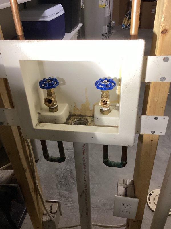 Responded to non-functioning washing machine shut-off valves that were experiencing leaks. Replaced both defective boiler drain-style shut-off valves with new brass quarter-turn ball valves featuring blue handles, installed in recessed wall box between studs. Both valves were connected to existing copper supply lines serving the laundry area, restoring proper water control and eliminating leaks.