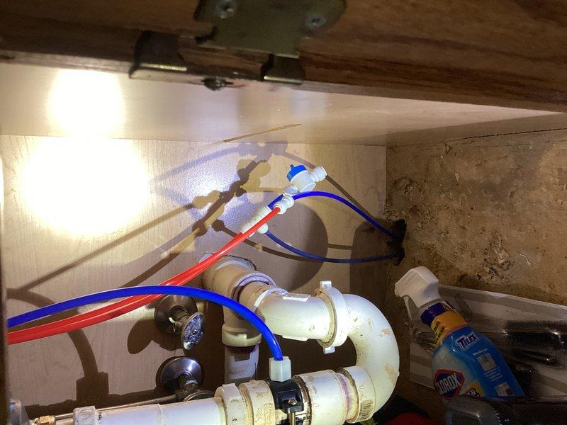 Responded to water leak in basement that resulted in collapsed ceiling panels and carpet damage following recent water softener installation. Upon investigation, identified the source as a compromised blue plastic water supply line connected to the reverse osmosis system that had been accidentally punctured by a drill during installation. Replaced the damaged plastic supply line with new tubing and verified all connections under the sink were secure and leak-free. Tested the reverse osmosis system to confirm proper operation and no additional leaks present.