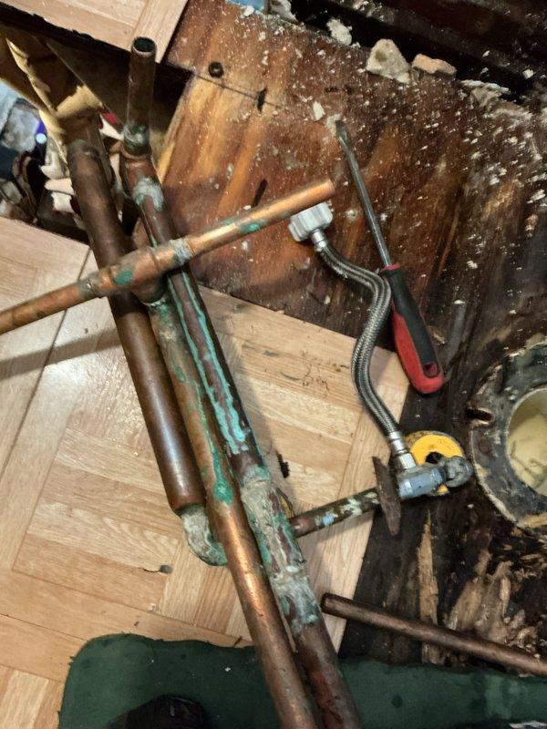 Responded to emergency plumbing call for multiple leaks that developed overnight. Located and repaired broken copper water line behind toilet within wall cavity, requiring access through wall opening. Replaced deteriorated bathroom faucet and complete kitchen sink assembly due to age and failure. Performed minor repairs to toilet fixtures including supply connections and internal components. Addressed underlying pipe issues beneath kitchen sink area where corrosion and aging copper lines showed significant oxidation and patina buildup. All work completed according to provided estimate, with multiple fixtures requiring replacement due to extensive deterioration throughout the plumbing system.