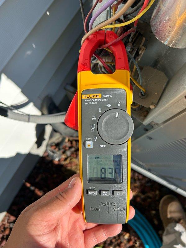 Performed comprehensive preventive maintenance inspection on air conditioning system. Verified furnace operation, confirmed filter condition acceptable, and checked condensate drain line for proper flow and drainage. Measured supply and return air temperature split at 20°F, indicating adequate system performance. 

Conducted outdoor unit inspection and found condenser coil moderately dirty with accumulated debris. Evaluated refrigerant circuit and confirmed system pressures and temperatures within manufacturer specifications for normal operation. Performed electrical diagnostics on compressor, measuring locked rotor amperage at 83.9A, which matched nameplate rating exactly.

Tested dual run capacitor using digital multimeter and identified compressor section reading 30 µF against rated specification of 45 µF, indicating significant capacitance loss. Fan motor capacitor section tested within acceptable tolerance range. Inspected contactor for pitting, burning, or wear and found contacts