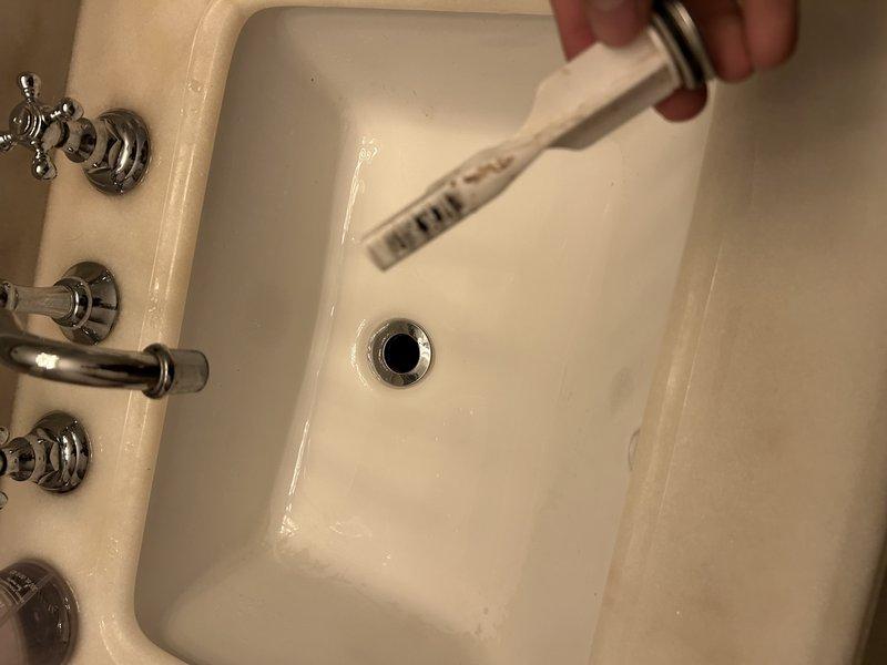 Responded to multiple plumbing issues throughout the property. Addressed bathroom sink drain obstruction with stuck stopper mechanism and faulty release valve assembly beneath sink. Investigated lack of hot water supply to bathroom shower fixture. Assessed malfunctioning garbage disposal unit. Inspected and evaluated cracked P-trap assembly at outdoor grill area ice drain location. Documented all conditions with photographic evidence for service records.
