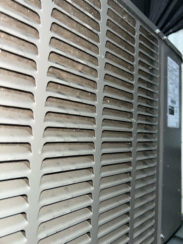 Completed comprehensive AC tune-up service on residential air conditioning system. Inspected outdoor condenser unit, noting moderate dust and debris accumulation on exterior louvered panels requiring attention during routine maintenance. Replaced severely clogged and damaged air filter at indoor air handler, which showed extensive dirt buildup and multiple tears compromising system airflow and efficiency.