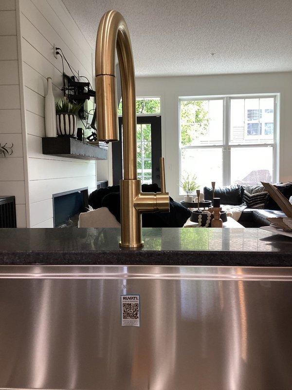 Installed customer-provided garbage disposal and kitchen faucet beneath kitchen sink. Connected braided stainless steel supply lines to angle stop valves with proper escutcheons at wall penetrations. Installed dishwasher supply line to existing water connection. Verified all connections for proper operation and checked for leaks. All fixtures tested and functioning correctly upon completion.