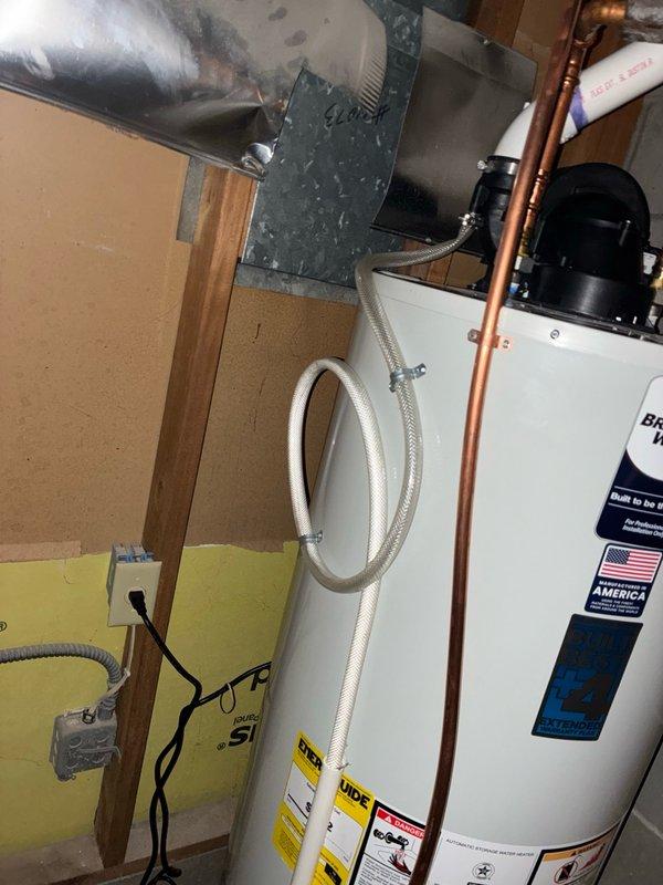 Responded to service call for recently installed tanked water heater producing unusual sloshing sounds audible both at the unit and exterior vent, along with water softener displaying blue flashing indicator light. Upon inspection, identified water heater flutter and moisture present in exhaust system. Ran condensation drain line to address moisture accumulation and resolve flutter condition, restoring normal operation to the water heater unit.