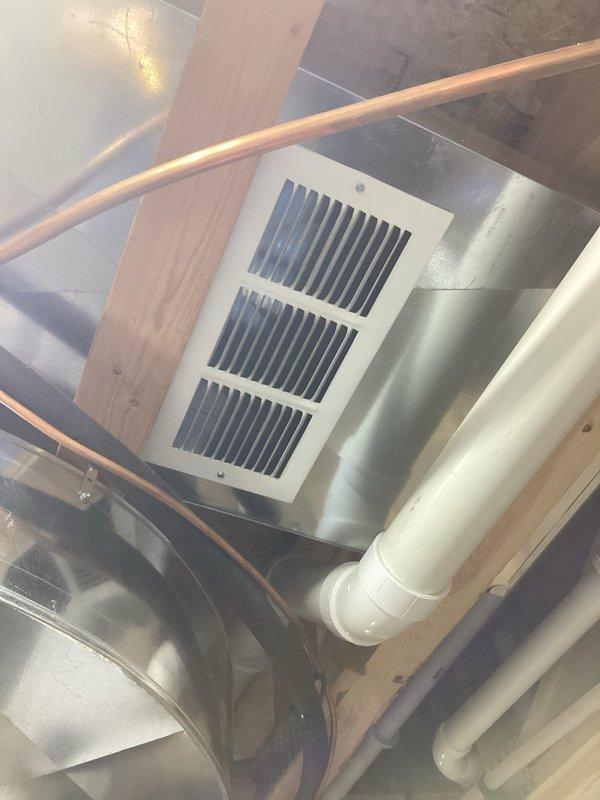 Responded to no cool complaint on 8-year-old system. Upon arrival, verified main floor thermostat holding at 69°F while basement thermostat read 65°F in off position. Conducted thorough inspection of return air system throughout residence. Found inadequate return air flow with disproportionate return vent distribution—large returns located in basement with minimal returns on main living levels. Tested and confirmed dampers operational. Diagnosed probable return air imbalance causing conditioned air to short-cycle through basement rather than properly circulating through main living areas. Documented findings with photos of basement ductwork, copper refrigerant lines, and thermostat display. Advised customer of return air distribution issue affecting system performance and cooling efficiency on upper levels.