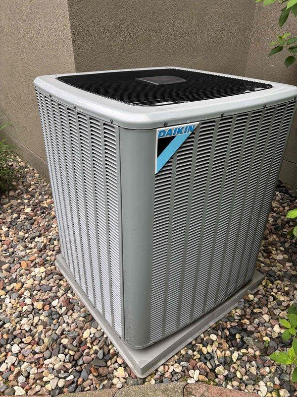 Performed comprehensive AC maintenance on one Daikin condenser unit with R-410A refrigerant. Conducted full system inspection including air filter, thermostat operation, temperature split analysis, condenser coils, motors, capacitors, compressor function, refrigerant charge levels, and condensate drain line. All components tested and found operating within normal parameters with system cooling properly at ambient temperature of 65 degrees.