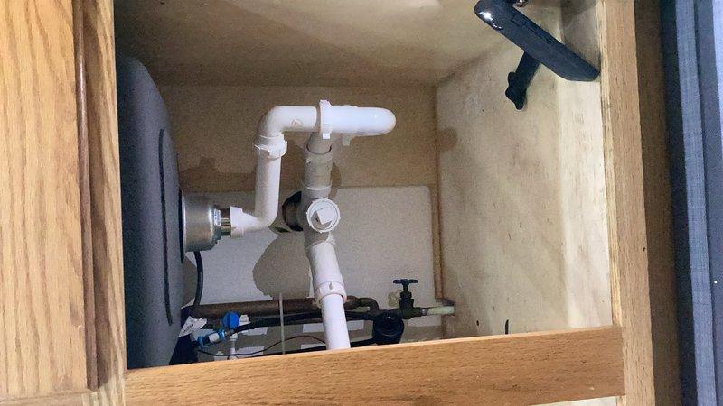 Installed customer-supplied kitchen faucet and completed full drain rebuild under sink. Replaced existing PVC drain assembly including P-trap, tailpiece, strainer, basket, and flange with new components up to 4 feet of piping. Connected new faucet to existing supply lines and shut-off valves. Verified all connections for proper seal and tested system for leaks. All fixtures operating correctly upon completion.